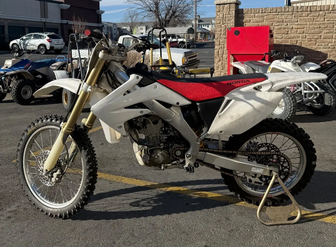 Honda CRF dirt bike on a stand outside the shop