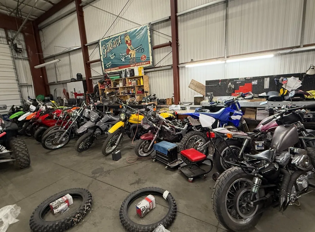 Dirt bikes, pit bikes and motorcycles lined up inside the OHV Service Center & Fab shop